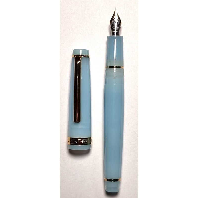 Baby Blue Jinhao 82 fountain pen uncapped beside its cap