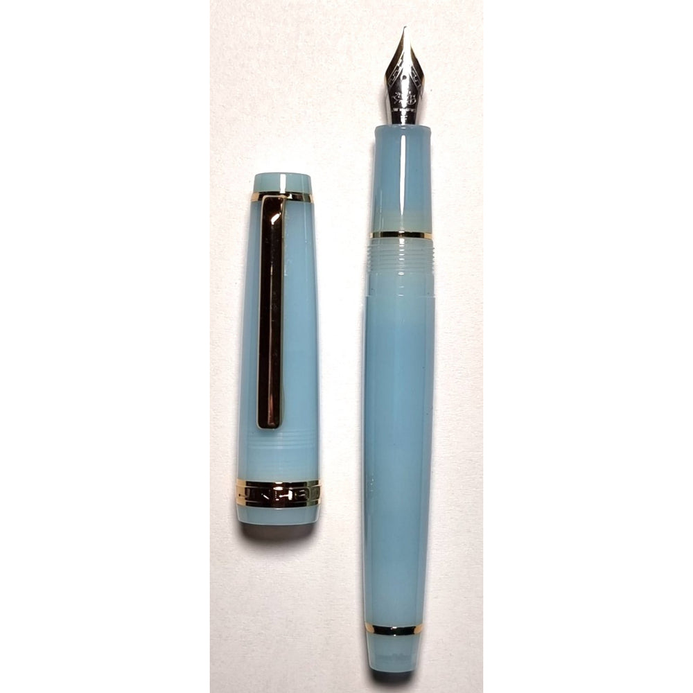 Baby Blue Jinhao 82 fountain pen uncapped beside its cap